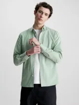 Camisa verde claro de popelín elástico, corte slim, con cierre frontal de botones, mangas largas y logo de Calvin Klein bordado en el pecho.