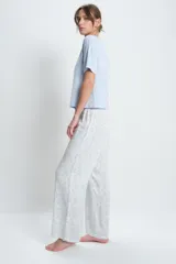Conjunto de pijama de viscosa, compuesto por una remera celeste de mangas cortas y un pantalón largo estampado con cintura elastizada.
