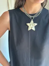 Collar doble con cadena de eslabones plateada, uno corto y otro largo con dije de estrella transparente con estampado de fantasmas.