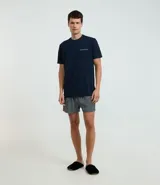 Conjunto de pijama corto para hombre, compuesto por una remera de manga corta con cuello redondo y bolsillo en el pecho, y un short con cintura elástica. Diseño a rayas finas.