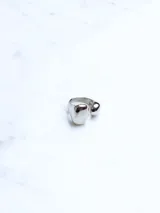 Anillo plateado con diseño moderno de dos esferas unidas.