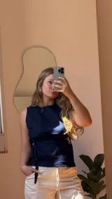 Musculosa azul marino de denim, con cuello redondo, sin mangas y lazos laterales para ajustar.