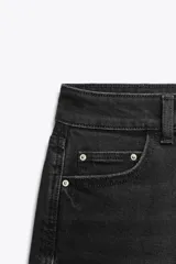Pantalón de jean negro de corte recto, tiro alto y largo tobillero.