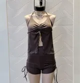 Top marrón con escote halter, corte ajustado y abertura en el abdomen.