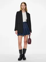 Blazer negro con cuello clásico, cierre de botones y bolsillos frontales. Tiene tachas plateadas en el frente y las mangas.