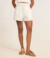 Short de cintura alta color blanco, confeccionado en viscolino, con cintura elástica en la espalda y cinturón incorporado con hebilla de media luna y tira doble para lazo.