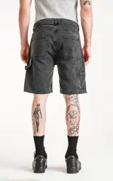 Bermuda de denim color negro lavado, estilo carpintero con bolsillo lateral utilitario y calce oversize.