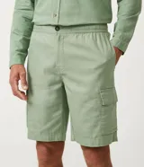 Bermuda cargo color verde claro, confeccionada en lino y algodón, con cintura elástica ajustable con botón y cierre. Cuenta con bolsillos laterales tipo cargo y bolsillos traseros. Marca Marfinno.
