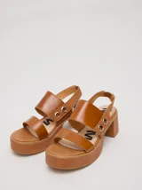 Sandalias negras de cuero con plataforma y taco ancho. Tienen correa trasera con elástico y doble argolla en la parte externa e interna.