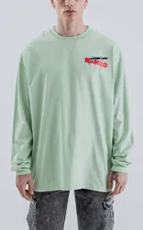 Remera verde agua de manga larga con corte oversize y hombros caídos. Estampado frontal con el nombre "Rambo" en rojo y negro, con una daga cruzada.