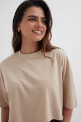 Remera color beige, corte cropped y estilo oversized.
