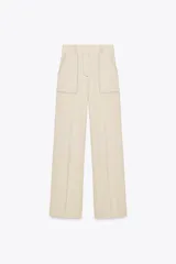 Pantalón de tiro alto color beige confeccionado con lino, de pierna recta, con bolsillos delanteros y falsos bolsillos de vivo en la espalda.