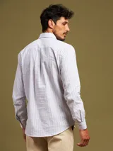 Camisa de vestir a rayas verticales azules y blancas, corte slim fit, con cuello abotonado y logo bordado en el pecho.