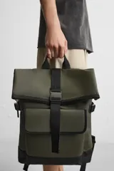Mochila verde militar con acabado engomado y base de cuero sintético negra. Tiene compartimento principal con cierre de solapa con cremallera y hebilla de liberación rápida, bolsillo interior con cremallera, compartimento para dispositivos electrónicos de hasta 13 pulgadas, bolsillo frontal con cierre imantado, asa de mano, asas de hombro ajustables y parte posterior acolchada.