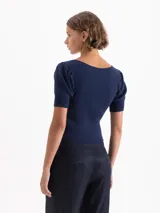 Top corto gris de punto acanalado, con escote redondo, manga corta abullonada y cierre frontal con tres ganchos decorados con piedras.