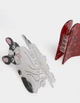 Set de dos broches para el pelo: uno con forma de bulldog francés blanco con manchas negras y otro con forma de corazón rojo con textura brillante.