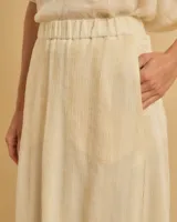 Falda larga color crema, de tela ligera con caída amplia y cintura elástica.