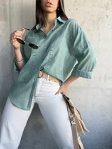 Camisa verde agua con detalles de encaje en el frente y mangas 3/4. Corte holgado y cuello clásico.