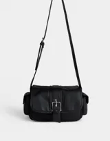 Bandolera negra de cuerina con solapa con hebilla metálica y cierre con broche a presión. Tiene correa regulable con hebilla y bolsillos laterales con broche a presión.