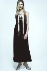 Vestido midi de terciopelo negro con escote pico y tirantes finos ajustables. Detalle de encaje en contraste en el escote.