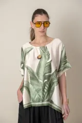 Blusa italiana color natural con estampado de hojas en tonos verdes. Tiene calce holgado y mangas cortas.