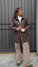 Chaqueta de cuero color marrón chocolate, con cuello clásico, cierre frontal con cremallera metálica, bolsillos laterales con solapa y corte recto.