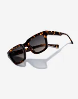 Gafas de sol Hawkers modelo Uptown, unisex, con montura cuadrada de carey marrón y lentes degradadas en gris.