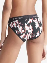 Bombacha bikini de algodón con estampado floral en tonos blanco y rojo sobre fondo negro. Cintura elástica con logo de Calvin Klein.