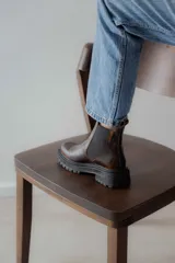 Bota Chelsea de cuero negro con elástico lateral y suela track.