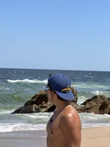 Gorra de béisbol azul marino con visera curva y bordado frontal en amarillo que dice "LOVE & PEACE" y debajo "PP:ONE".