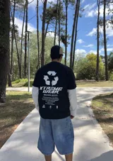 Remera negra de algodón de corte oversize con estampado en la espalda con un logo de reciclaje y la frase "XTREME WEAR BREAKING RULES".