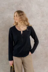 Remera negra de algodón con cartera de lino y botones al tono.