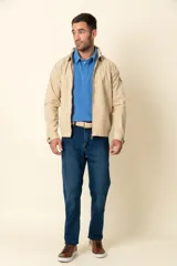 Campera color beige con cierre frontal, cuello camisero, bolsillos laterales y elástico en la cintura. Detalle de bolsillo en la manga izquierda.