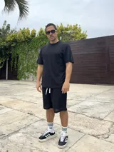 Conjunto negro tejido calado, compuesto por una remera de corte cuadrado y shorts.