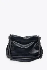 Bolso de hombro marrón oscuro de cuero sintético, con solapa y cierre magnético. Tiene un asa de cadena plateada y tres compartimentos internos, uno de ellos con cierre de cremallera.