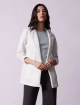 Blazer blanco de Robert Louis con cuello con solapa, abertura central con botón, bolsillos delanteros y mangas 3/4 con frunces.