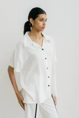 Camisa de corte amplio con estampado floral en tonos celeste, gris y blanco, confeccionada en lino y fibrana.