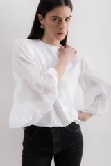 Blusa blanca de algodón con mangas largas abullonadas de gasa y puños elásticos.
