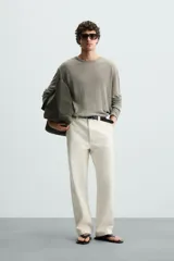 Jersey color verde claro de punto tejido en hilatura ligera de lino, corte relaxed fit, cuello redondo y manga larga con terminaciones en rib.