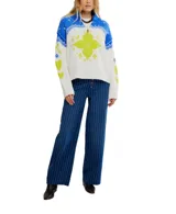 Sweater tejido en color blanco y rojo, con diseño de jacquard. Presenta cuello alto con media cremallera, corte holgado y extragrande, y dobladillos y escote acanalados.