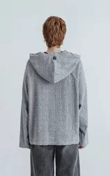 Hoodie gris de lanilla con textura, corte oversize crop y costuras expuestas.