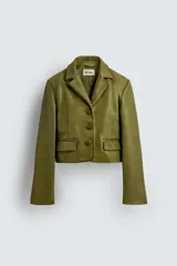 Blazer corto de cuero color verde oliva, con cuello con solapas de pico, manga larga con puños con abertura, bolsillos de solapa en la cintura, efecto vintage y cierre frontal con botones.
