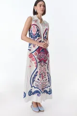 Vestido largo color crema con estampado cachemir en tonos marrones, con cuello camisero, sin mangas y abotonado al frente.