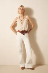 Pantalón jean blanco de tiro medio, ajustado en la cintura y sutilmente acampanado desde la cadera hasta el ruedo.