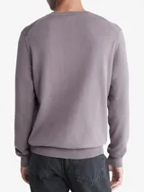 Sweater Calvin Klein de algodón color lila, de corte clásico, cuello redondo y logo bordado en el pecho.