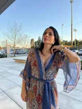 Vestido largo estampado con escote en V, mangas anchas y lazo en la cintura.