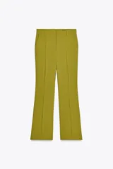 Pantalón de vestir color verde oliva, de tiro medio, corte flare y bolsillos laterales.