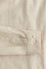 Camisa color crema en mezcla de lino y algodón, de corte regular fit, manga larga con puños abotonados, cuello inglés, tapeta clásica, canesú en la espalda, bolsillo superior abierto y bajo redondeado.