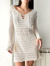 Vestido corto de crochet color crema, con mangas largas y cuello redondo.