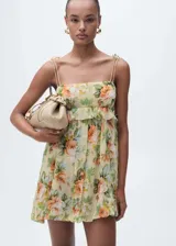 Vestido corto de gasa color amarillo con estampado floral, tirantes finos dobles, escote recto, cierre lateral con cremallera y forro interior.